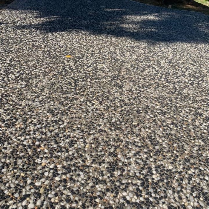 A close view of an exposed aggregate surface with mixed grey and cream stone