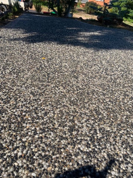 A close view of an exposed aggregate surface with mixed grey and cream stone