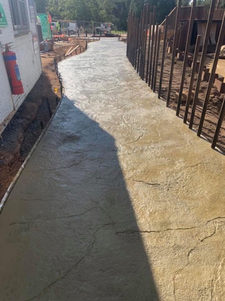 A stamped concrete path with a stone pattern pressed into the surface