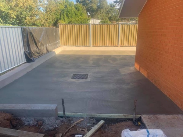 A finished shed floor with a drain grate set into the slab