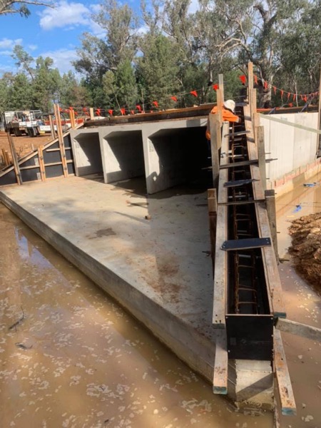 A concrete apron and box culverts with a formed headwall being set up