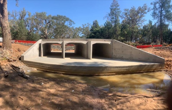 A precast box culvert headwall sitting in a shallow watercourse