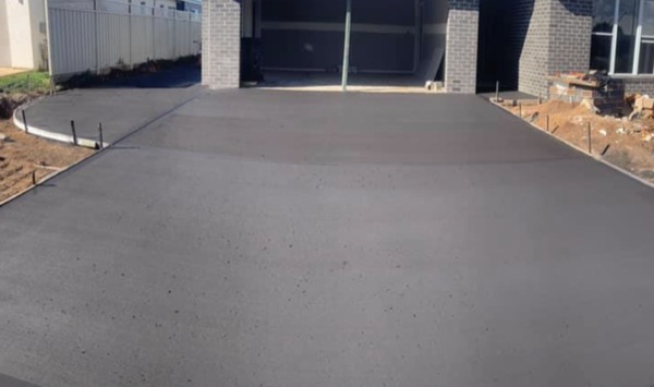 A finished driveway slab running up to an open garage door