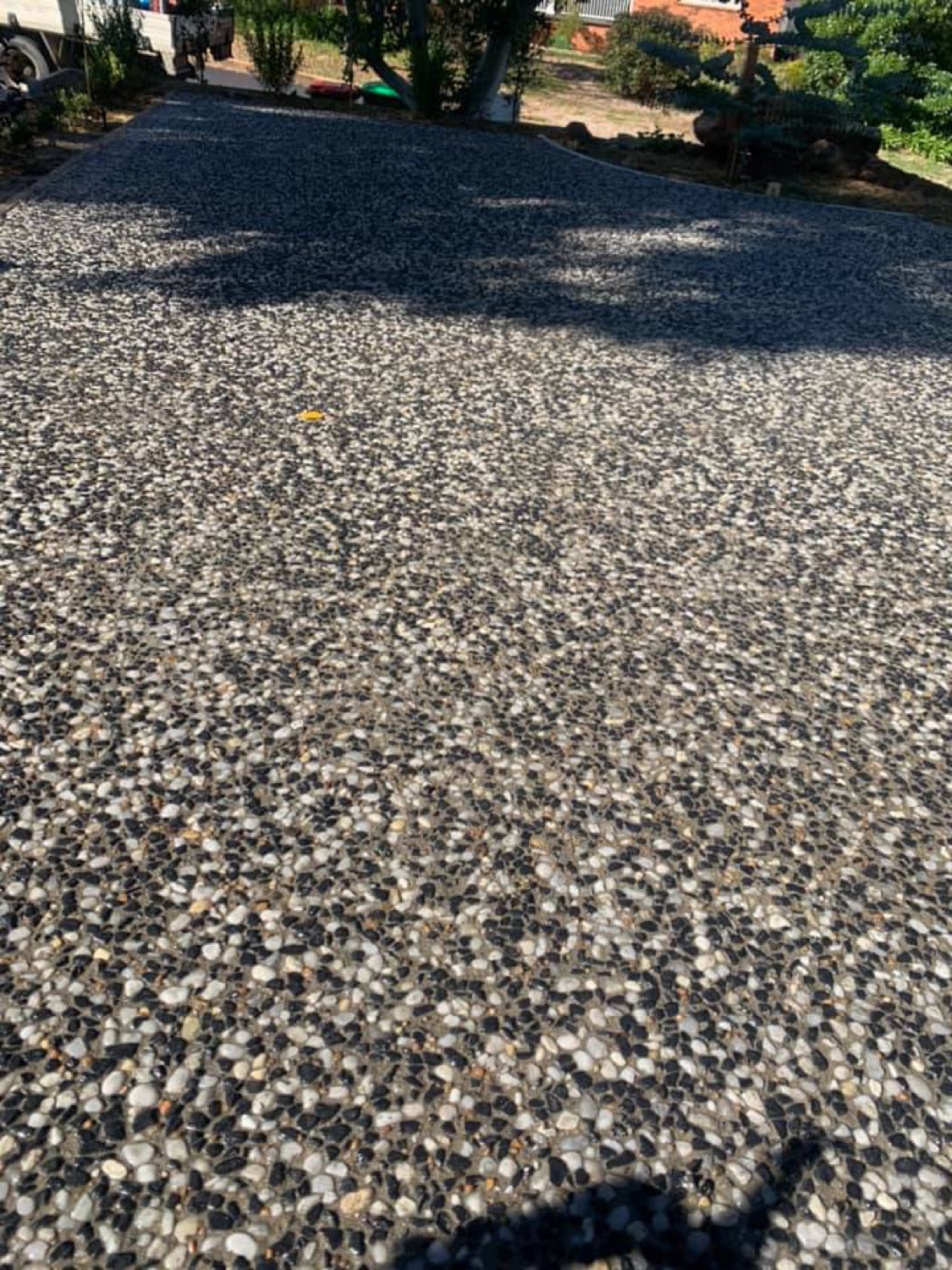 A close view of an exposed aggregate surface with mixed grey and cream stone